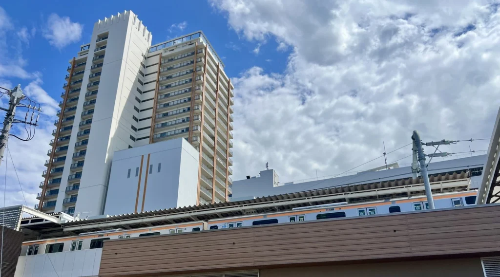 武蔵小金井駅付近の高層住宅と中央線の電車を見上げた街並み